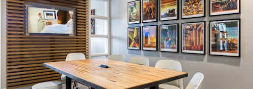 Interior view of conference room at AMLI Frisco Crossing apartment building with wood table, chairs and big screen TV