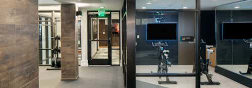 Spin cycles and fitness on demand featured at AMLI Riverfront Green apartments with a view into the elevator hallway
