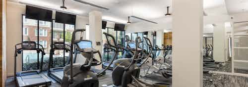 AMLI Frisco Crossing fitness center with treadmills and other cardio machines and mounted TVs and ceiling fans above