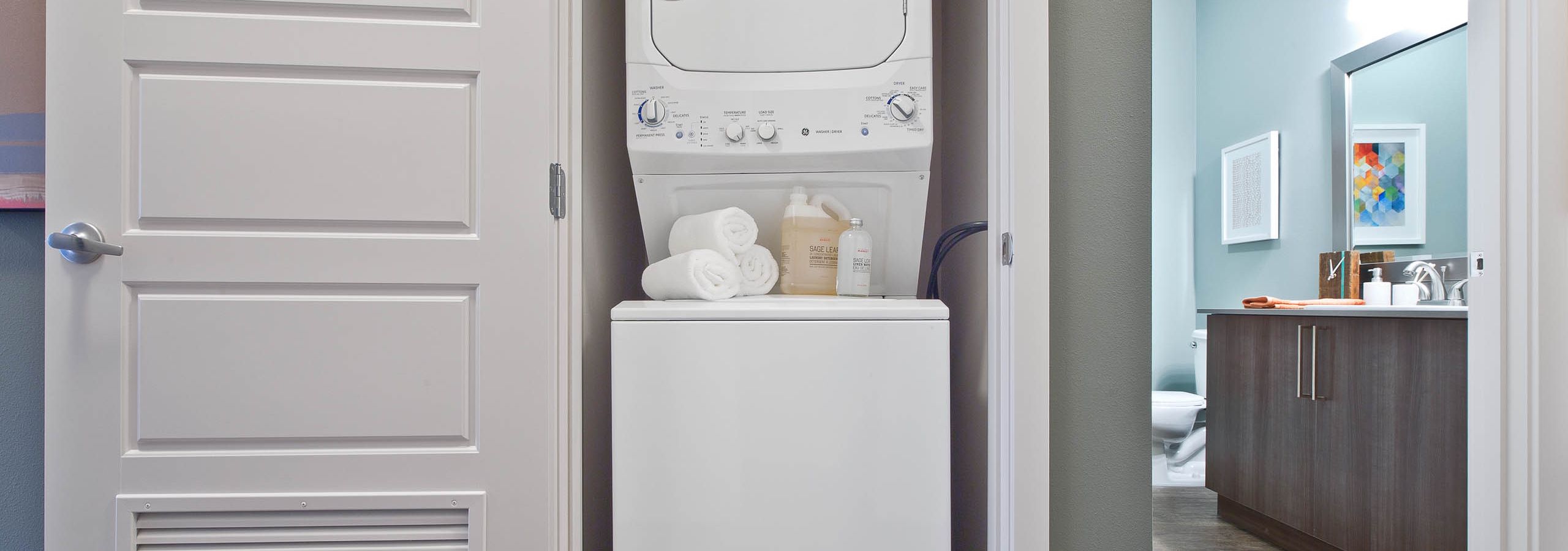 Stacked washer and dryer in a dedicated laundry closet at AMLI South Lake Union apartments.