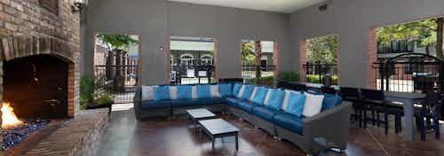 Interior view of AMLI Memorial Heights cabana building with fireplace at left and large couch seating in middle