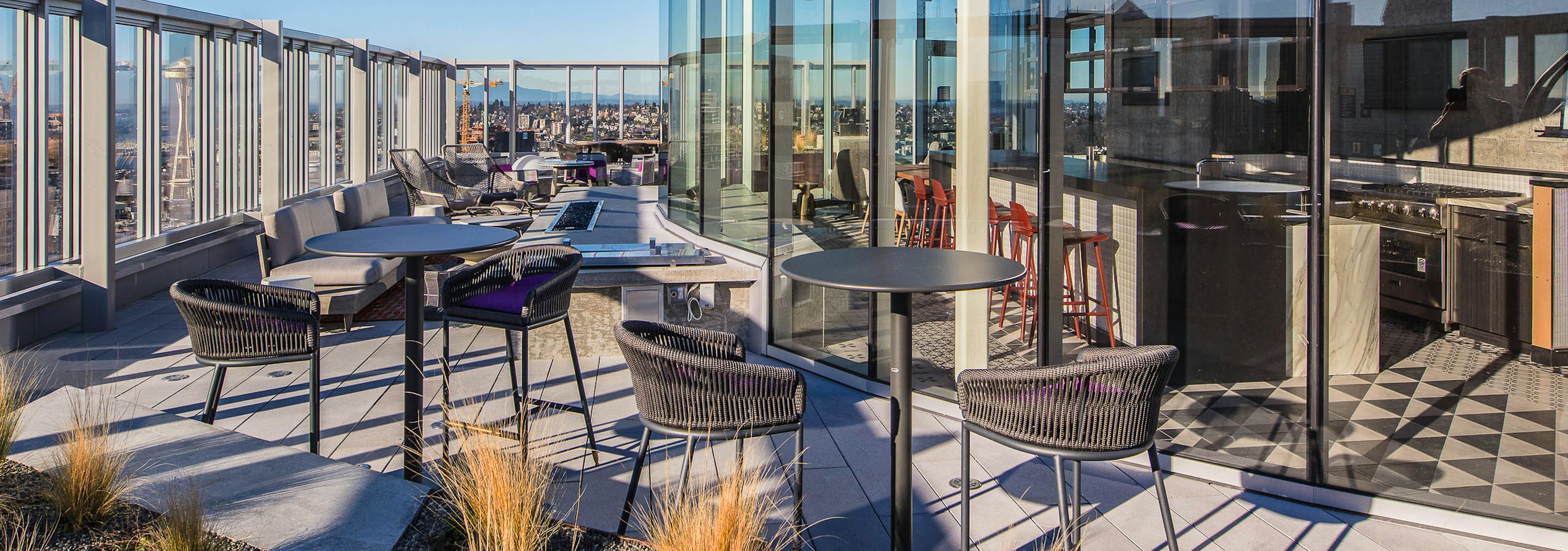 Exterior deck of AMLI Arc with seating and fire pit and views of Seattle 