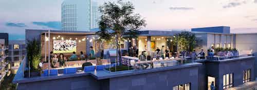 Nighttime rendering of AMLI Old Pasadena rooftop deck lounge lined with plants and lights with city buildings in background