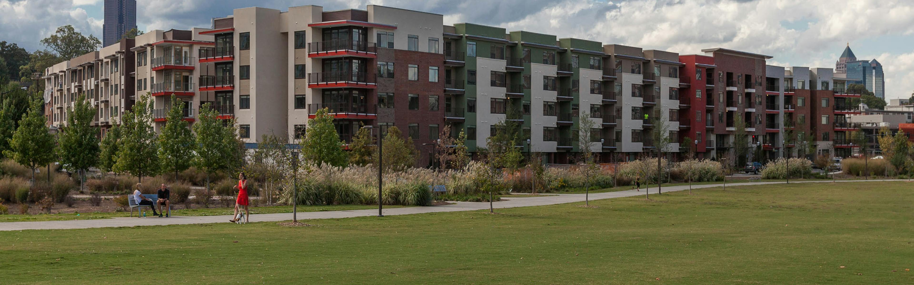 View of AMLI Ponce Park steps away from Historic Old 4th Ward Park with luscious green grass area and concrete walking trails