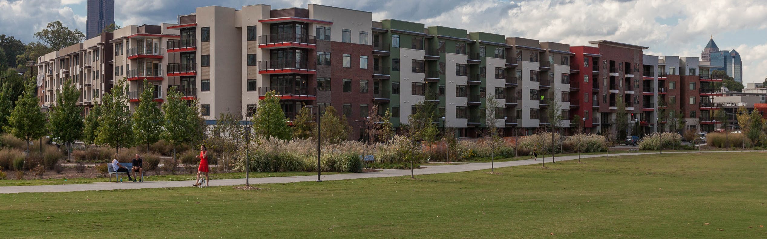 View of AMLI Ponce Park steps away from Historic Old 4th Ward Park with luscious green grass area and concrete walking trails