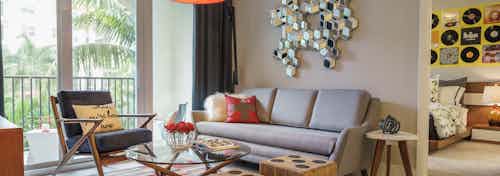An apartment living room at AMLI Sawgrass Village with tables shaped like dice and contemporary Modern-style furniture