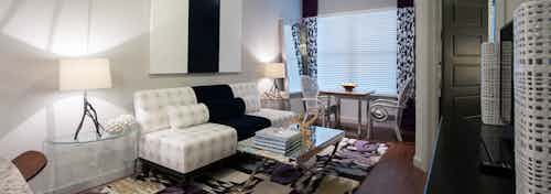 Interior view of beautifully decorated living room with wood floors and large window at AMLI Uptown apartment building