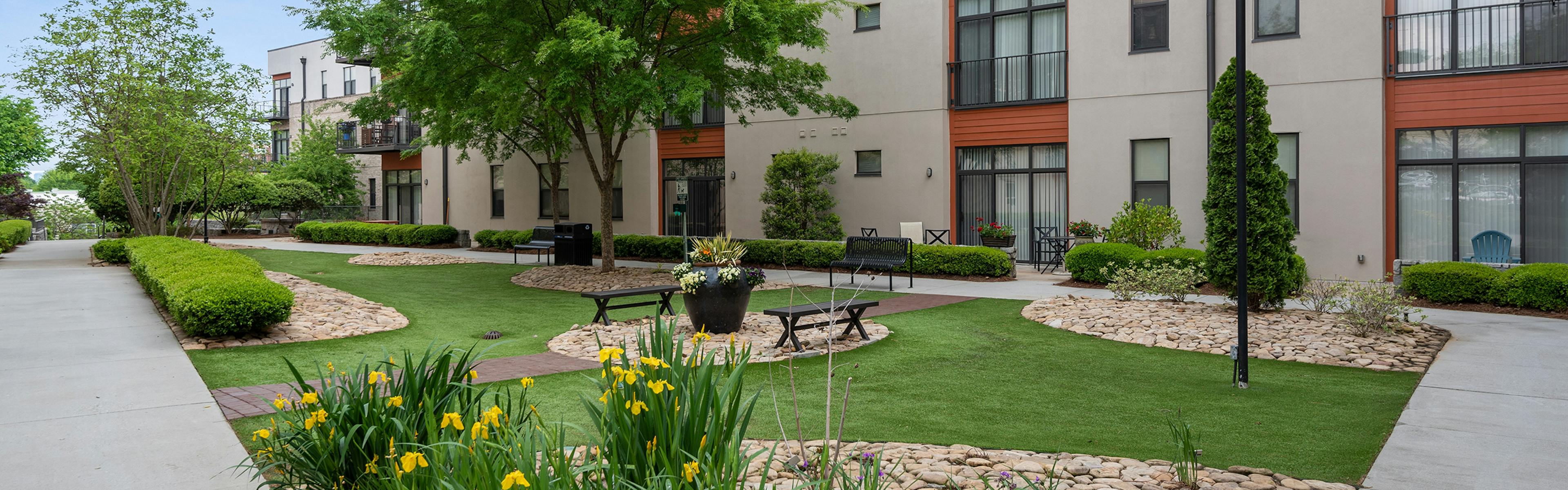 AMLI Old 4th Ward outside courtyard with luscious green grass and tulips with benches to sit on to breathe in fresh air