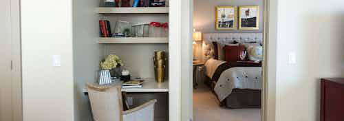 Interior view of built-in desk and shelves and a glimpse into beautifully decorated bedroom at AMLI River Oaks apartments