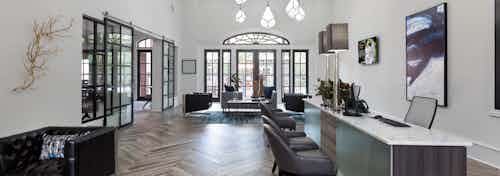 Interior view of AMLI Memorial Heights apartments leasing office with desks and seating area and doors to pool in back