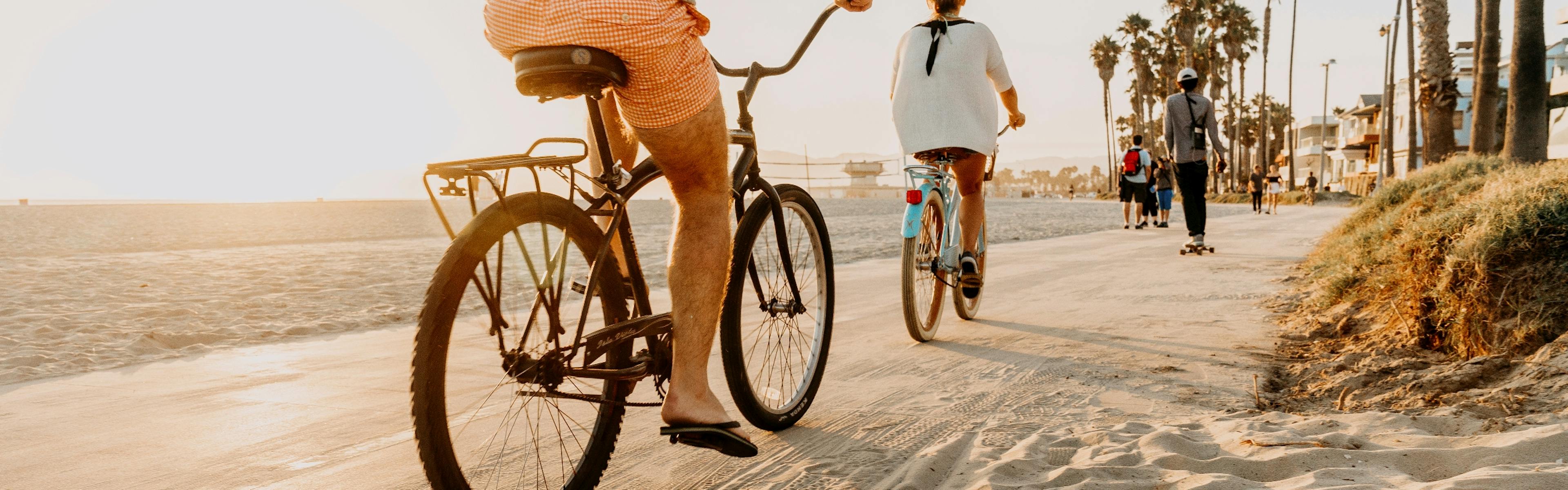 Daytime view of sandy Shoreline pedestrian bike path in Long Beach with people riding bicycles, skateboarding and walking