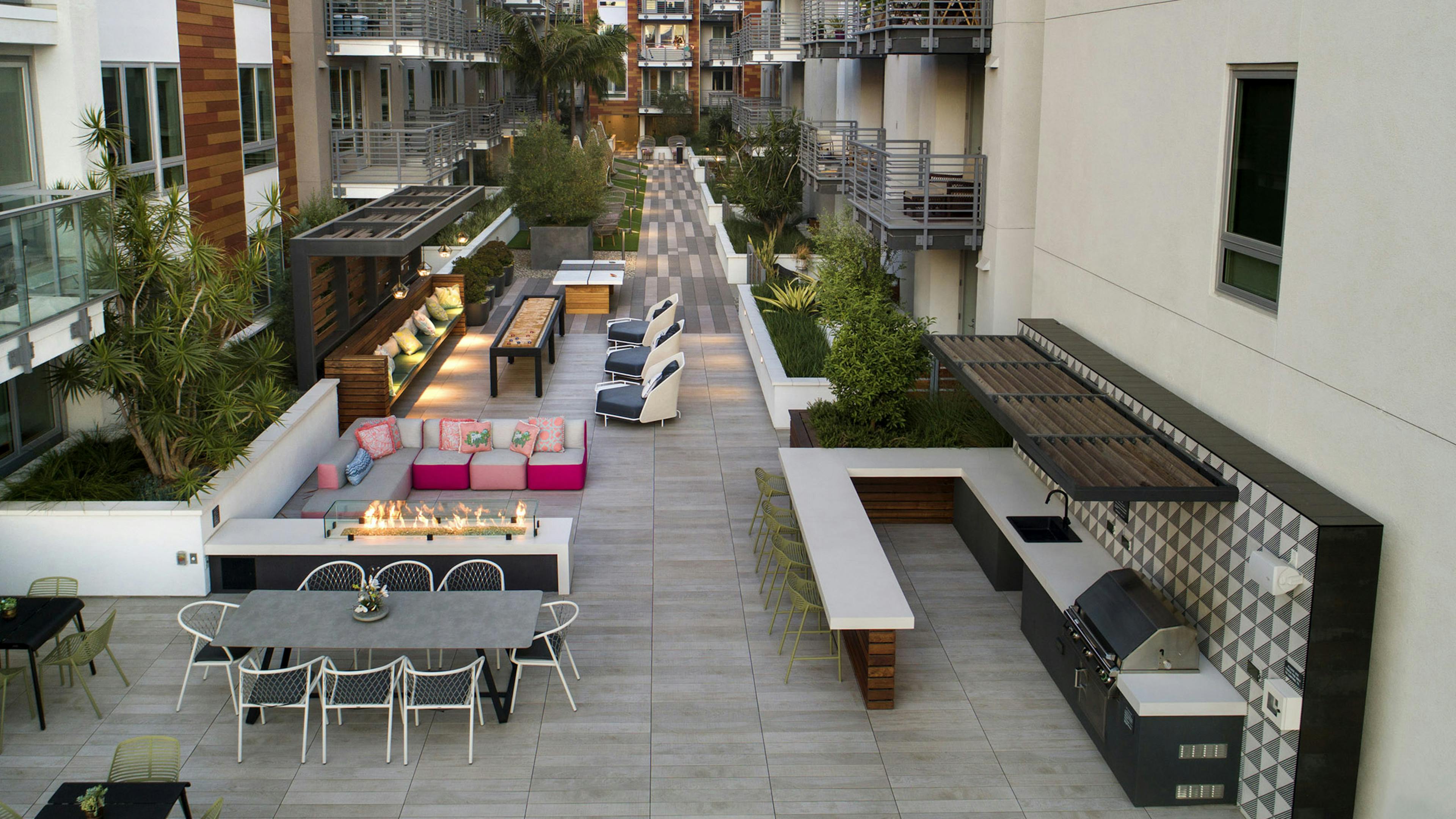 Aerial dusk view of gaming courtyard at AMLI Park Broadway with plentiful seating and grilling station and fire pit