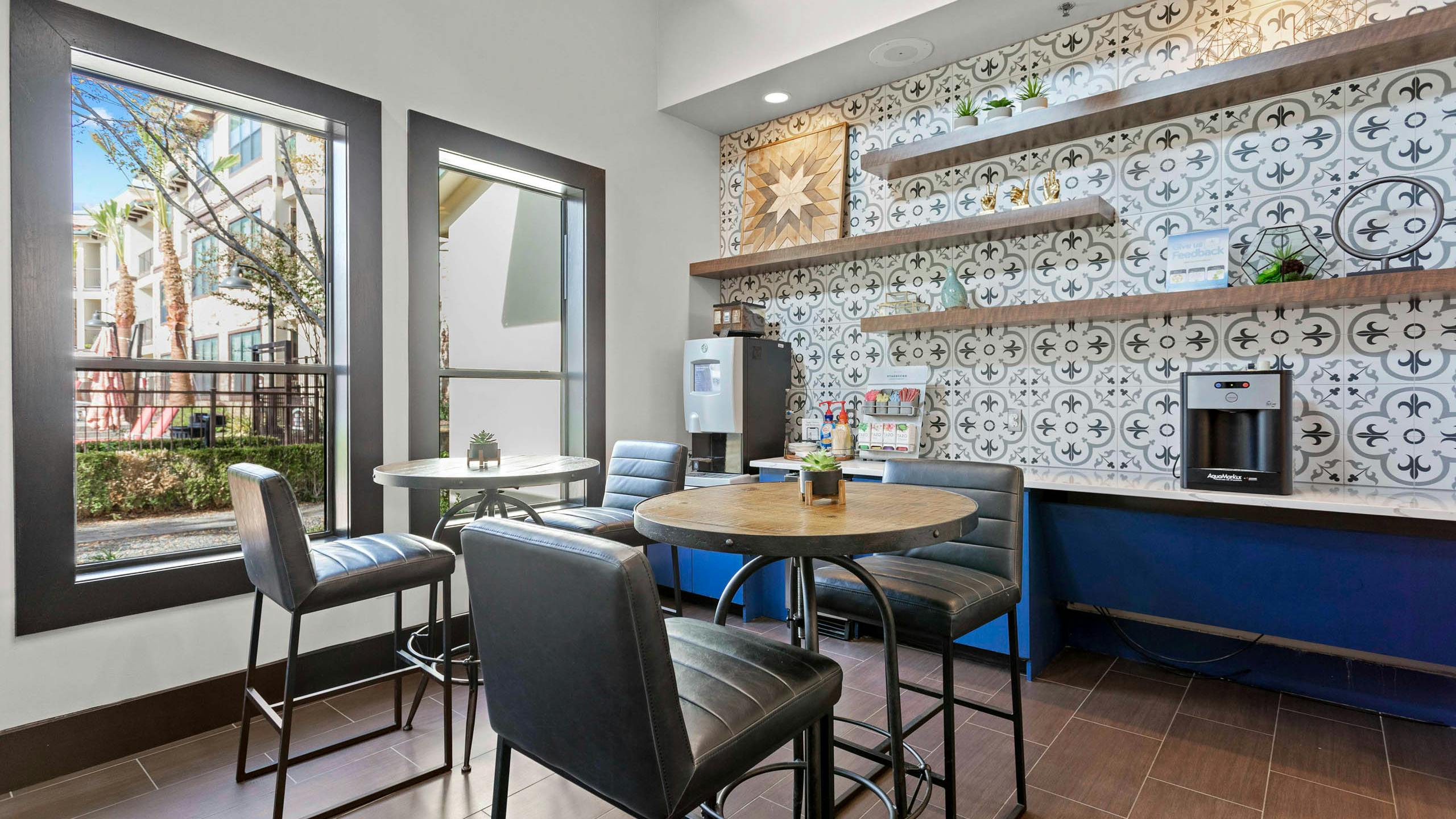 Java café for AMLI at Escena apartments with a colorful tile backsplash and leather bar stools surrounding wood high top tables
