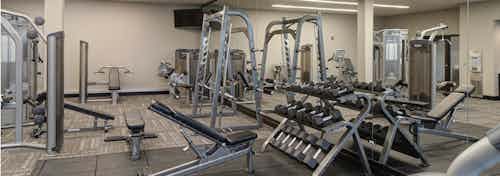 Expansive fitness center at AMLI Deerfield apartment community with various weight machines as well as free weights