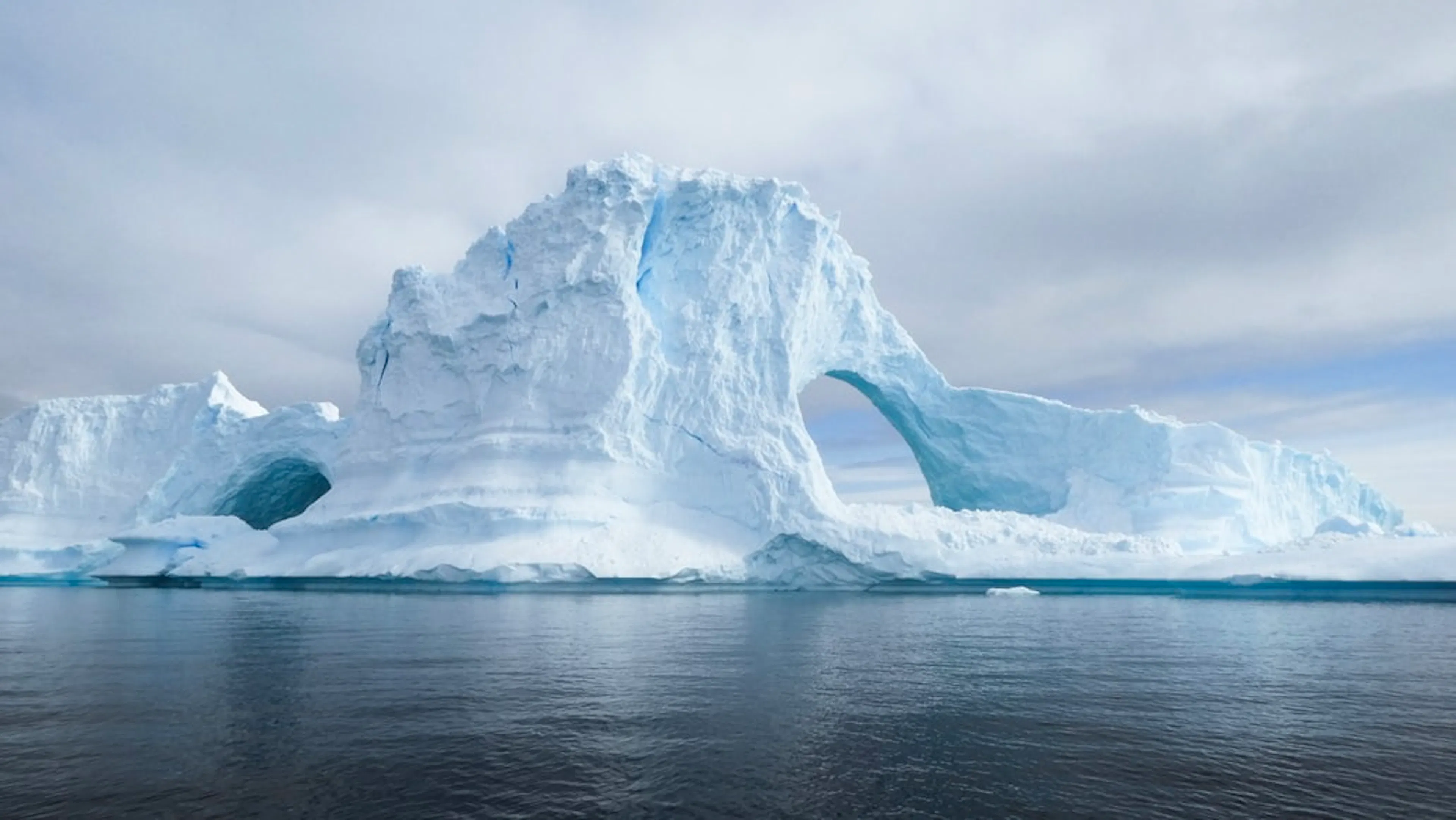 A large iceberg in the Antarctic Ocean on a cloudy day