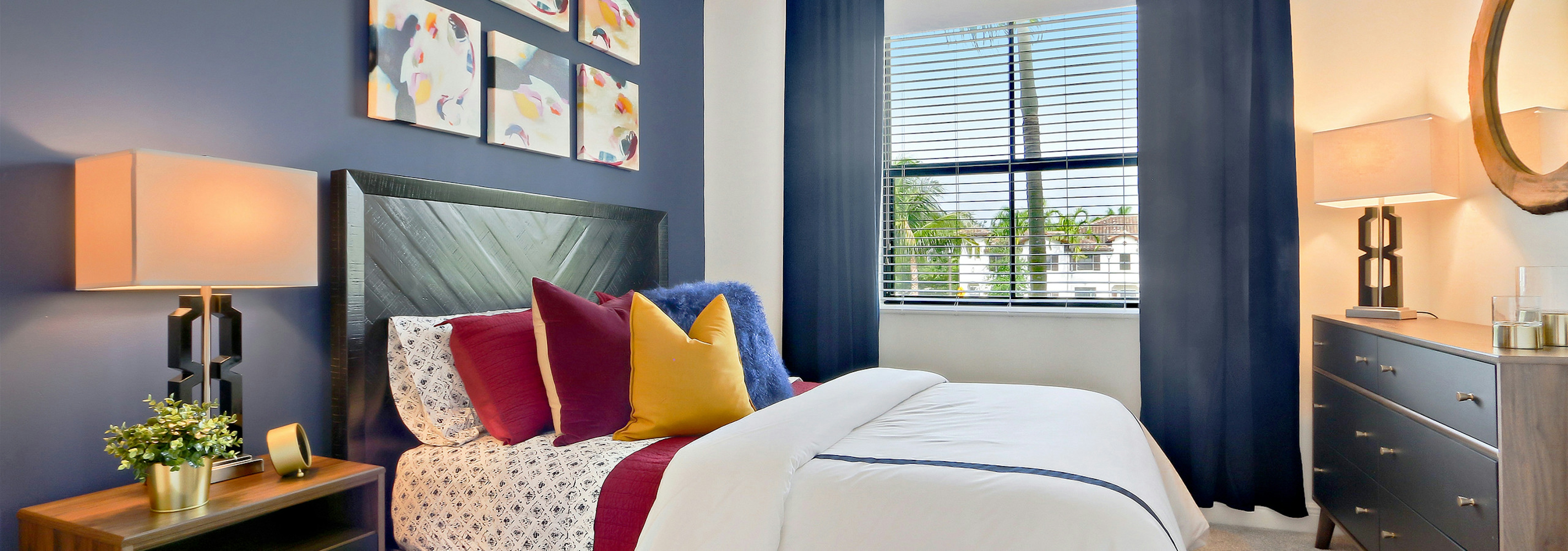 Interior view of AMLI Toscana Place townhome bedroom with bed centered on wall with décor and view from a window