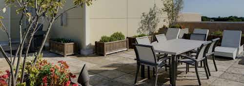 Another view of the rooftop at AMLI Evanston showing outdoor eating set up with reclining lounge chairs visible in the back