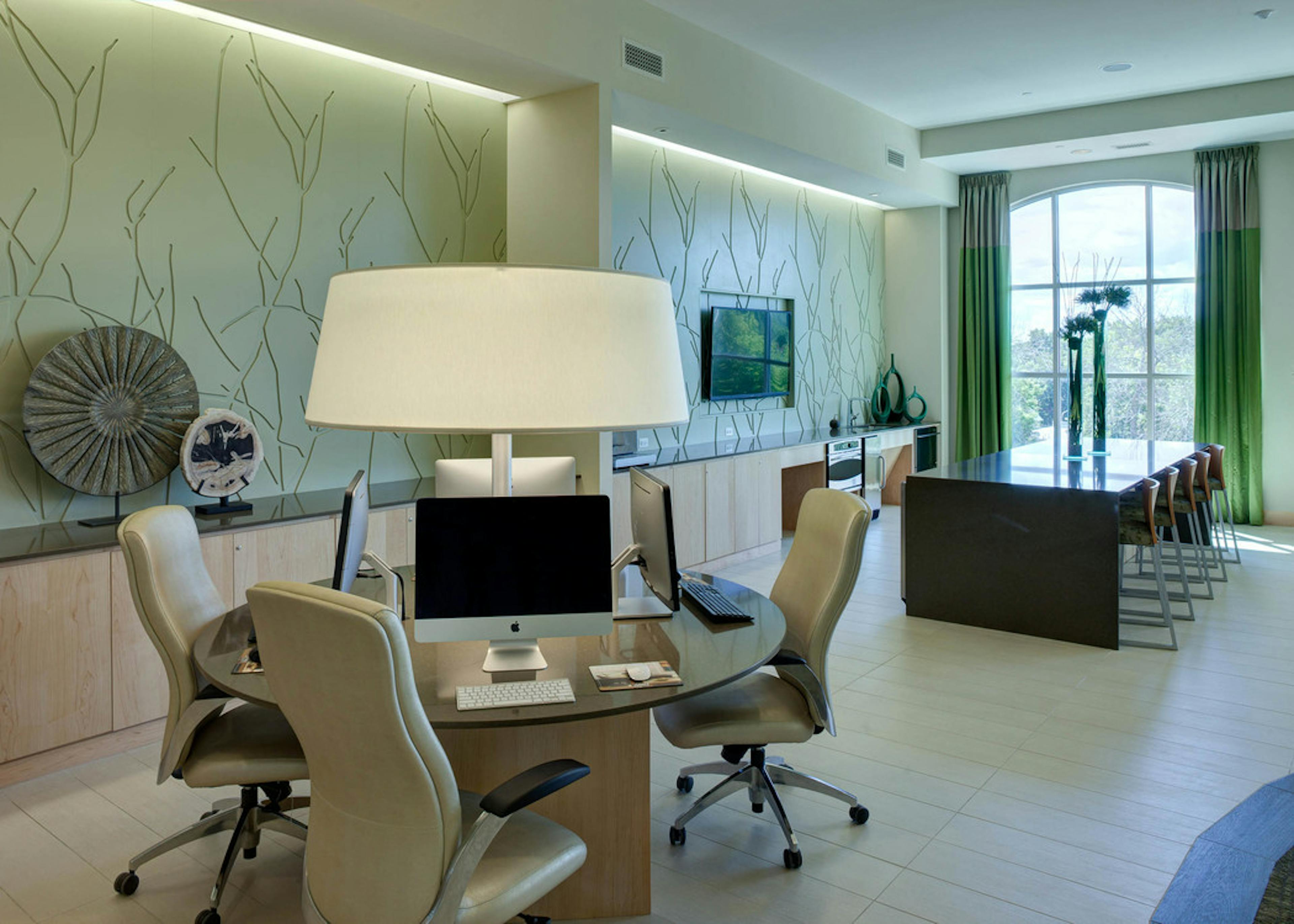 AMLI Evanston business center with a round conference table and desktop computers as well as a longer table in the background
