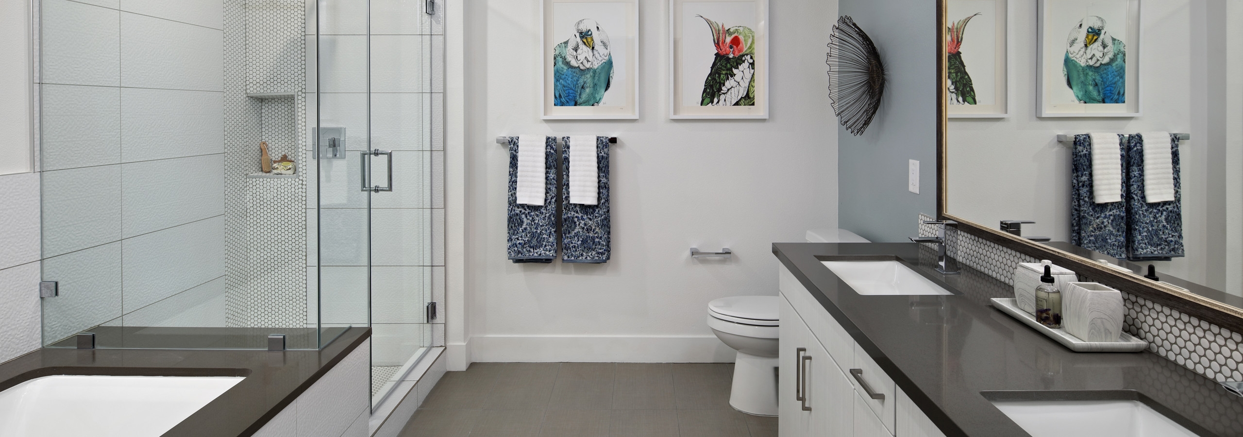 Interior of AMLI Marina Del Rey bathroom with quartz countertop, standing shower with frameless doors, tub and tile flooring