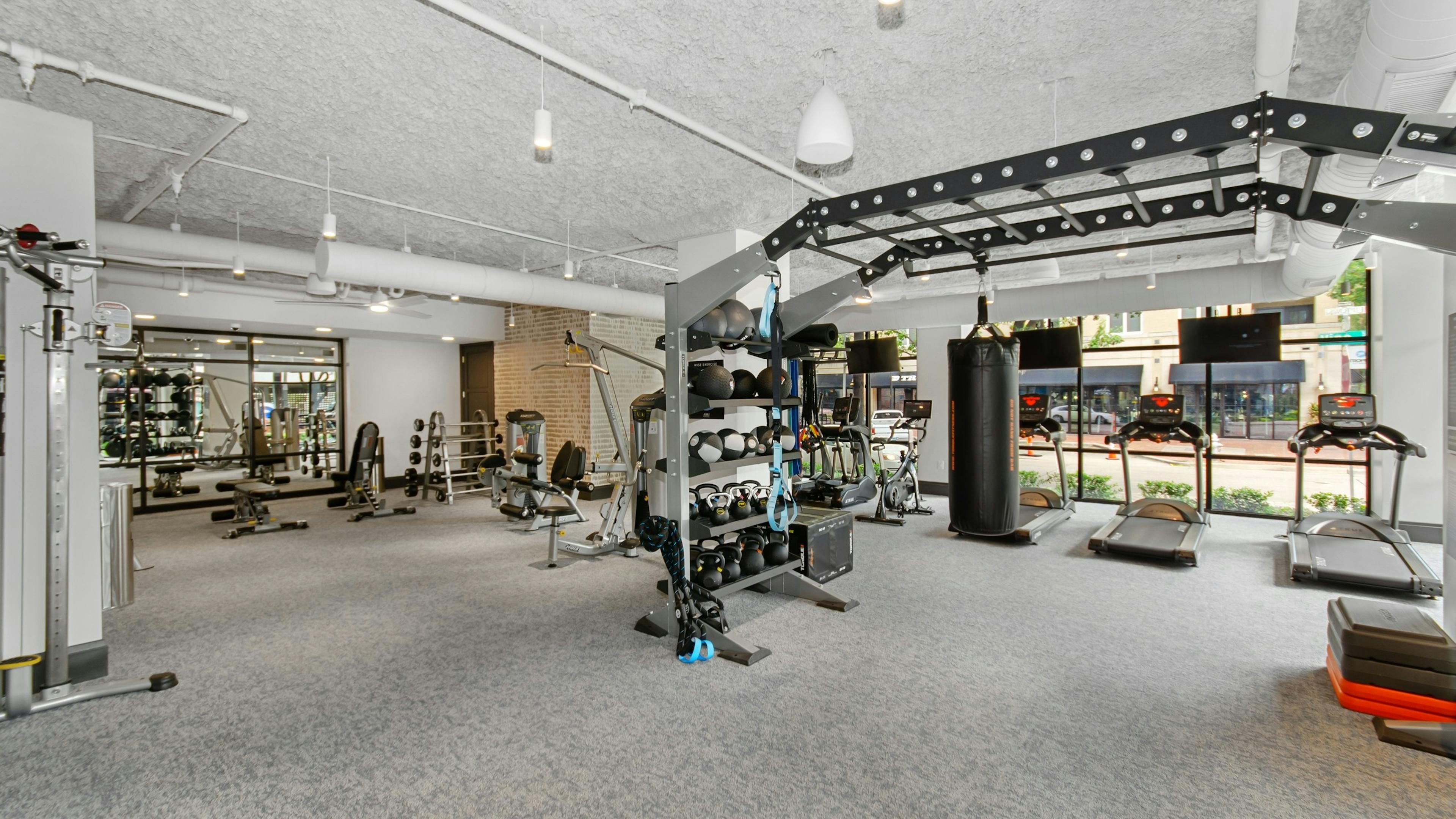 AMLI Quadrangle fitness center with a multipurpose weight training machine and treadmills facing the outside street