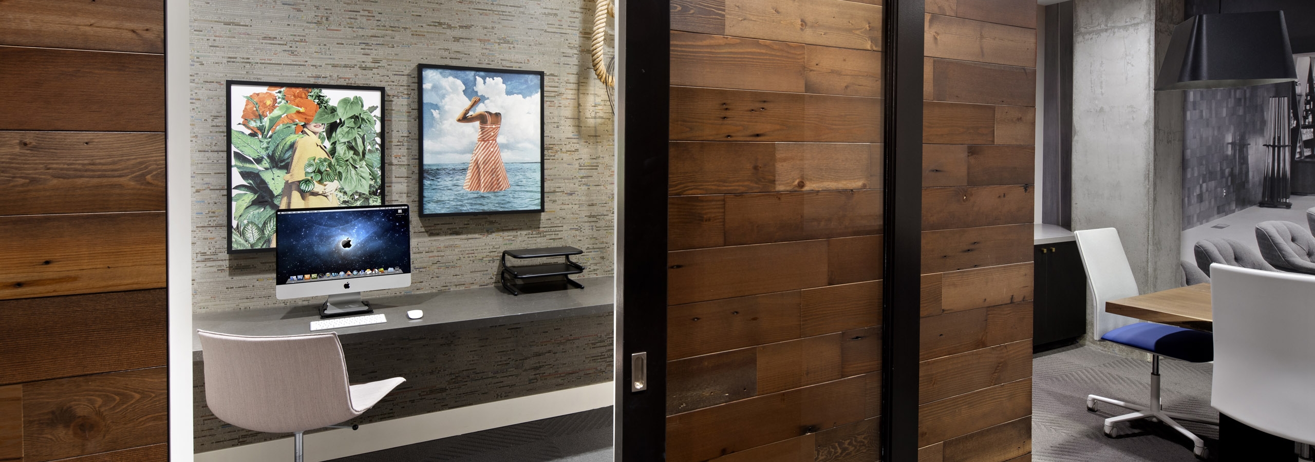 Peak into private office at AMLI Park Broadway apartments business center with wood paneled wall and modern glass barn door