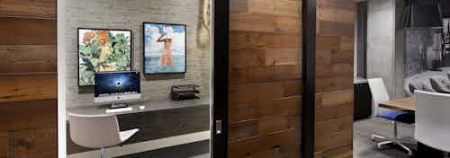 Peak into private office at AMLI Park Broadway apartments business center with wood paneled wall and modern glass barn door