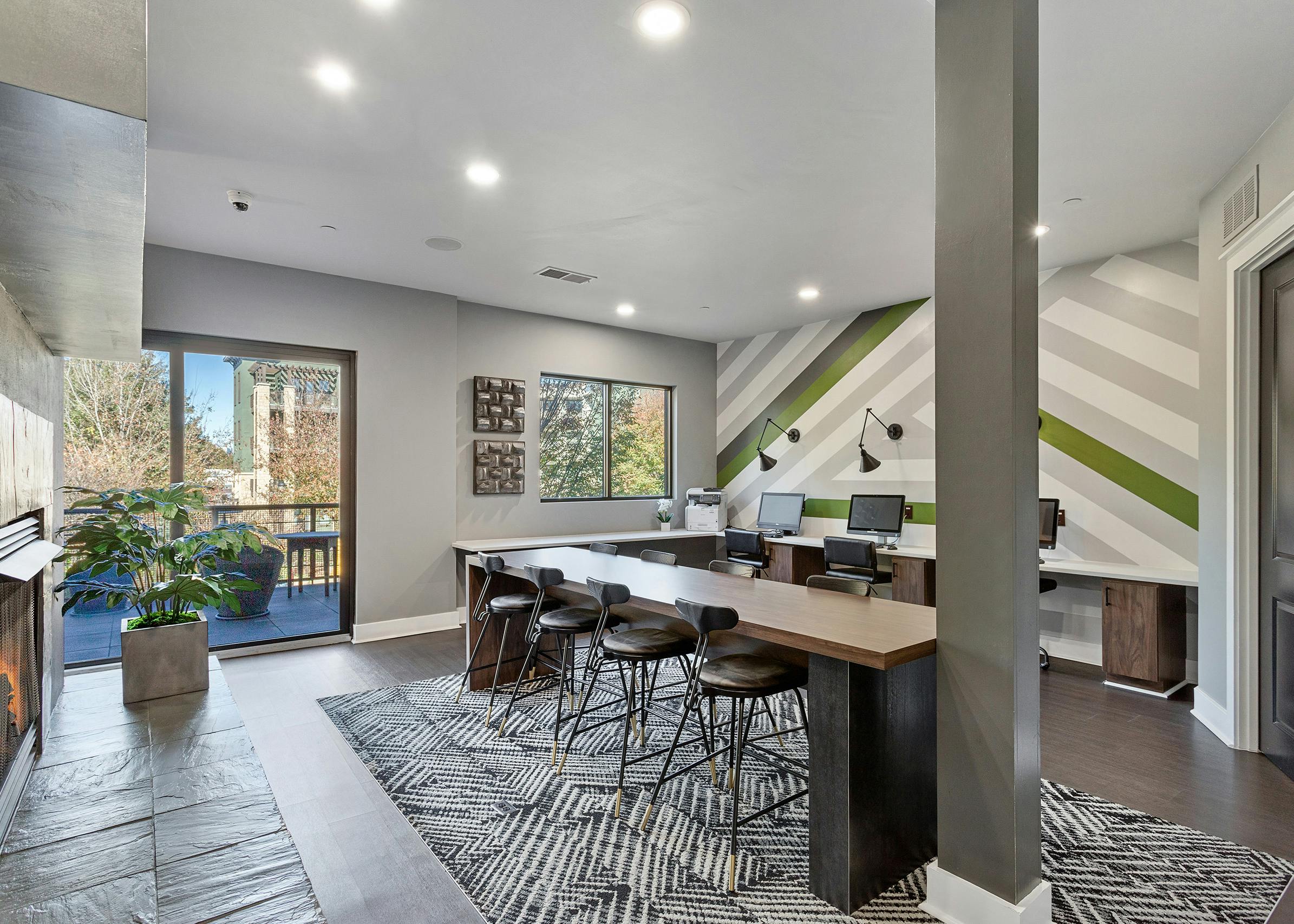 Interior view of AMLI Parkside cyber café with striped accent wall and long desks with computers and chairs and a gray pillar