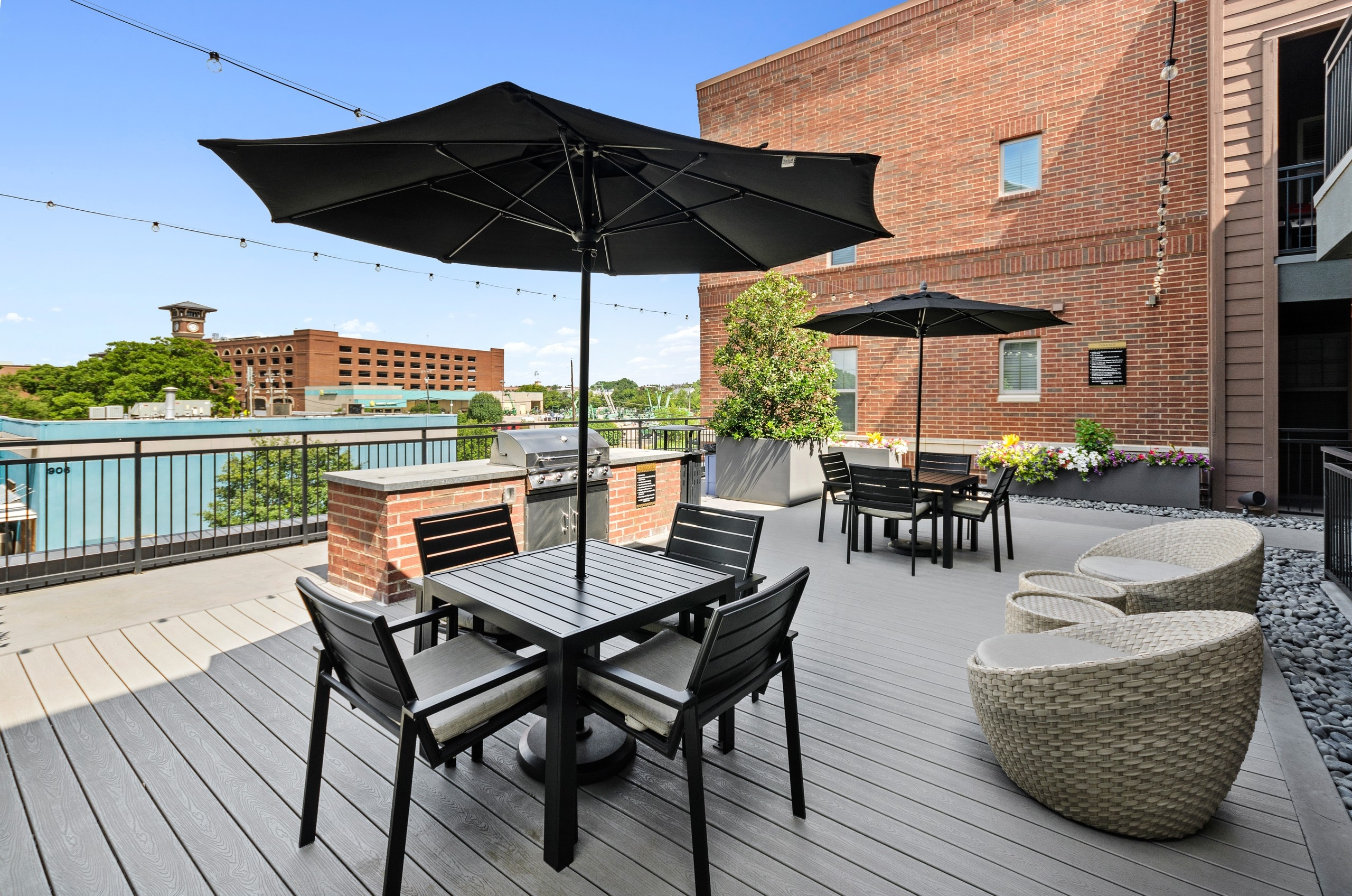 AMLI Grapevine rooftop grill area viewing Grapevine clocktower with black shaded seating areas and a stainless grill