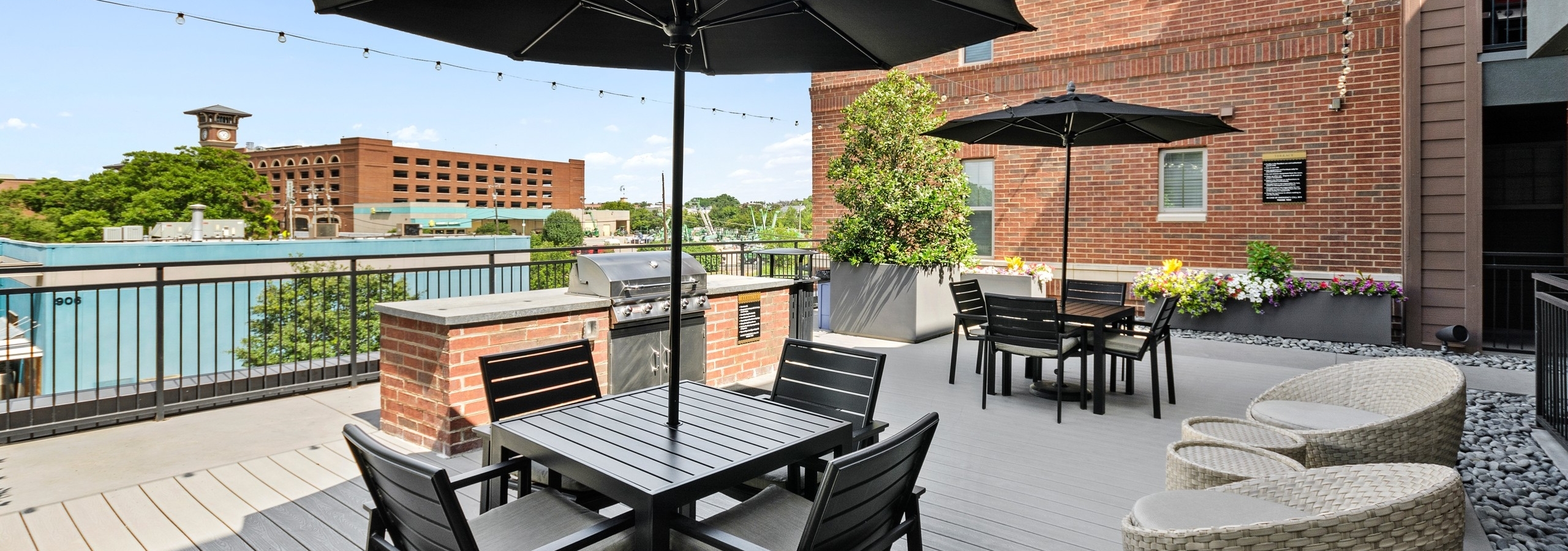 AMLI Grapevine rooftop grill area viewing Grapevine clocktower with black shaded seating areas and a stainless grill