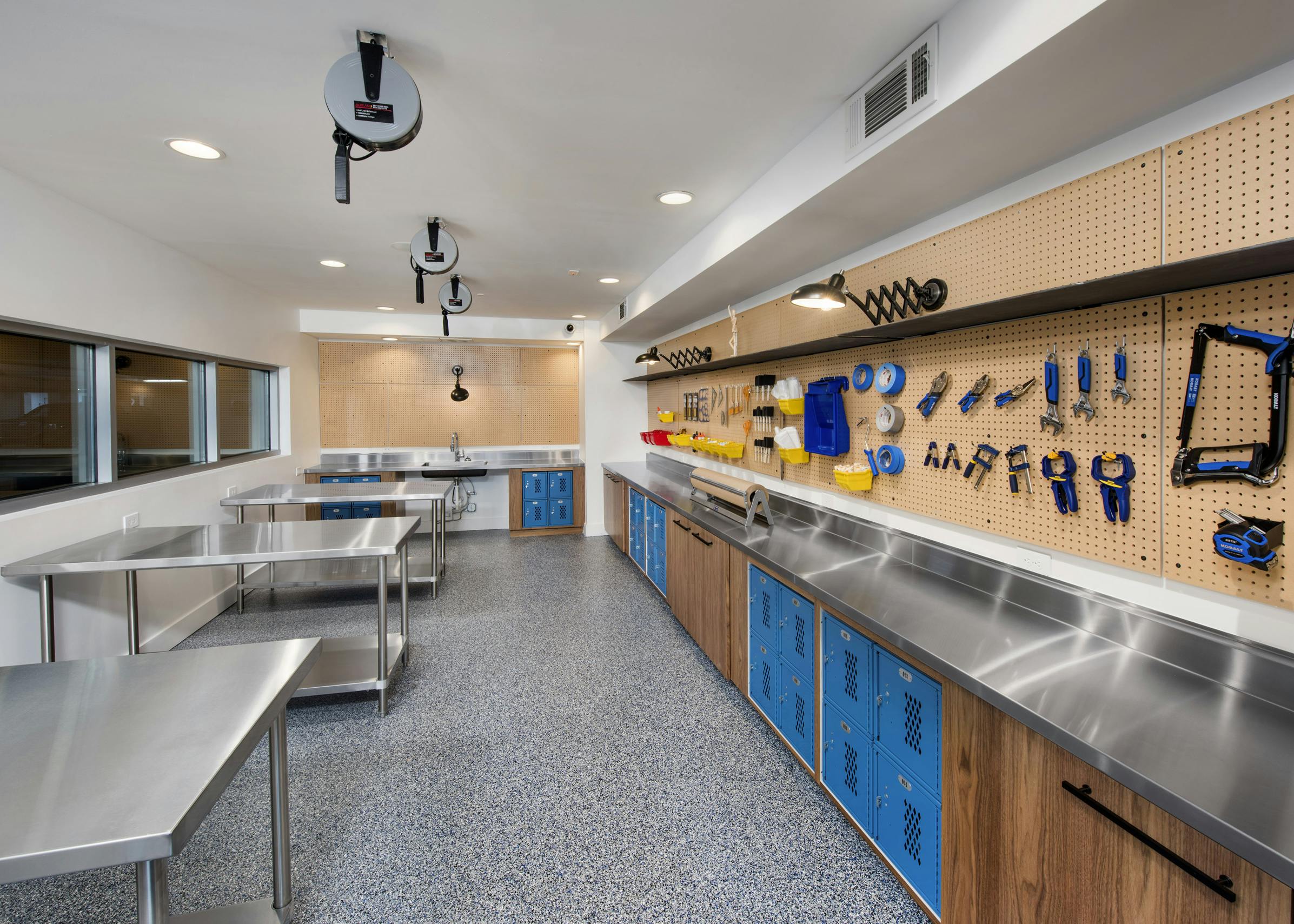 DIY maker space at AMLI Decatur with tools on peg wall, lockers, sink and work areas for residents to gather and create