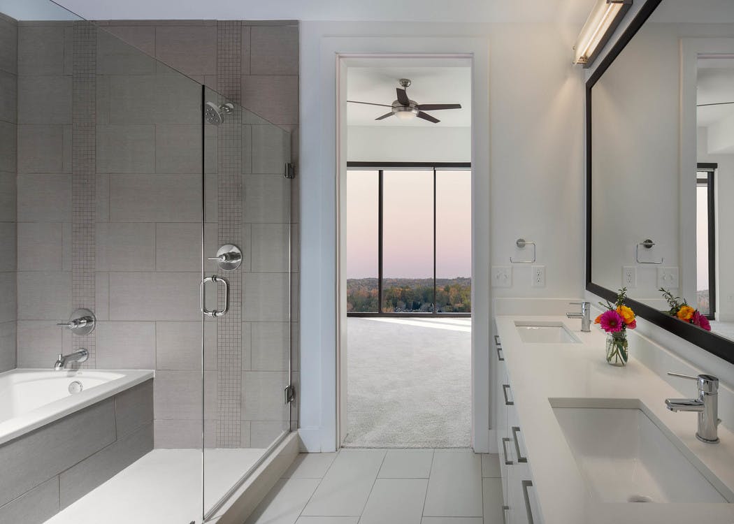 AMLI 3464 bathroom with double vanity sinks across from a glass door which opens up to a standing shower and separate bathtub