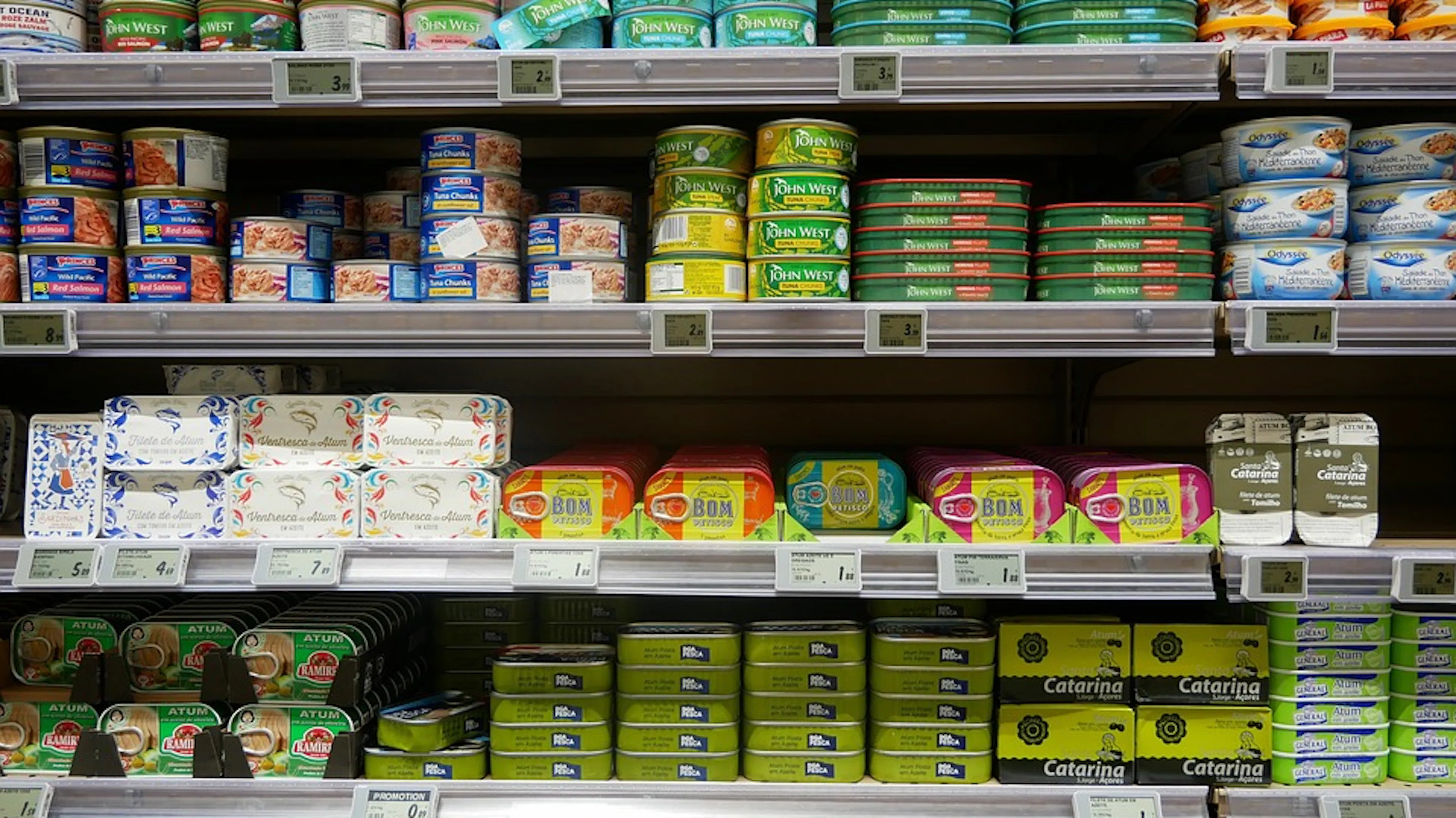 A grocery shelf filled with cans of tuna, chicken and other canned meats