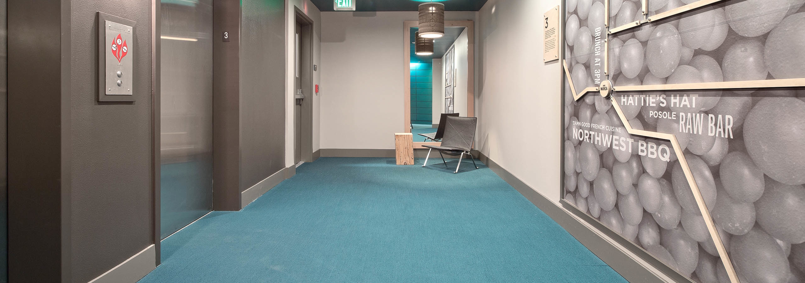 View of the waiting area outside the elevator bank at AMLI Mark24 with a custom map decoration on the wall displaying Ballard