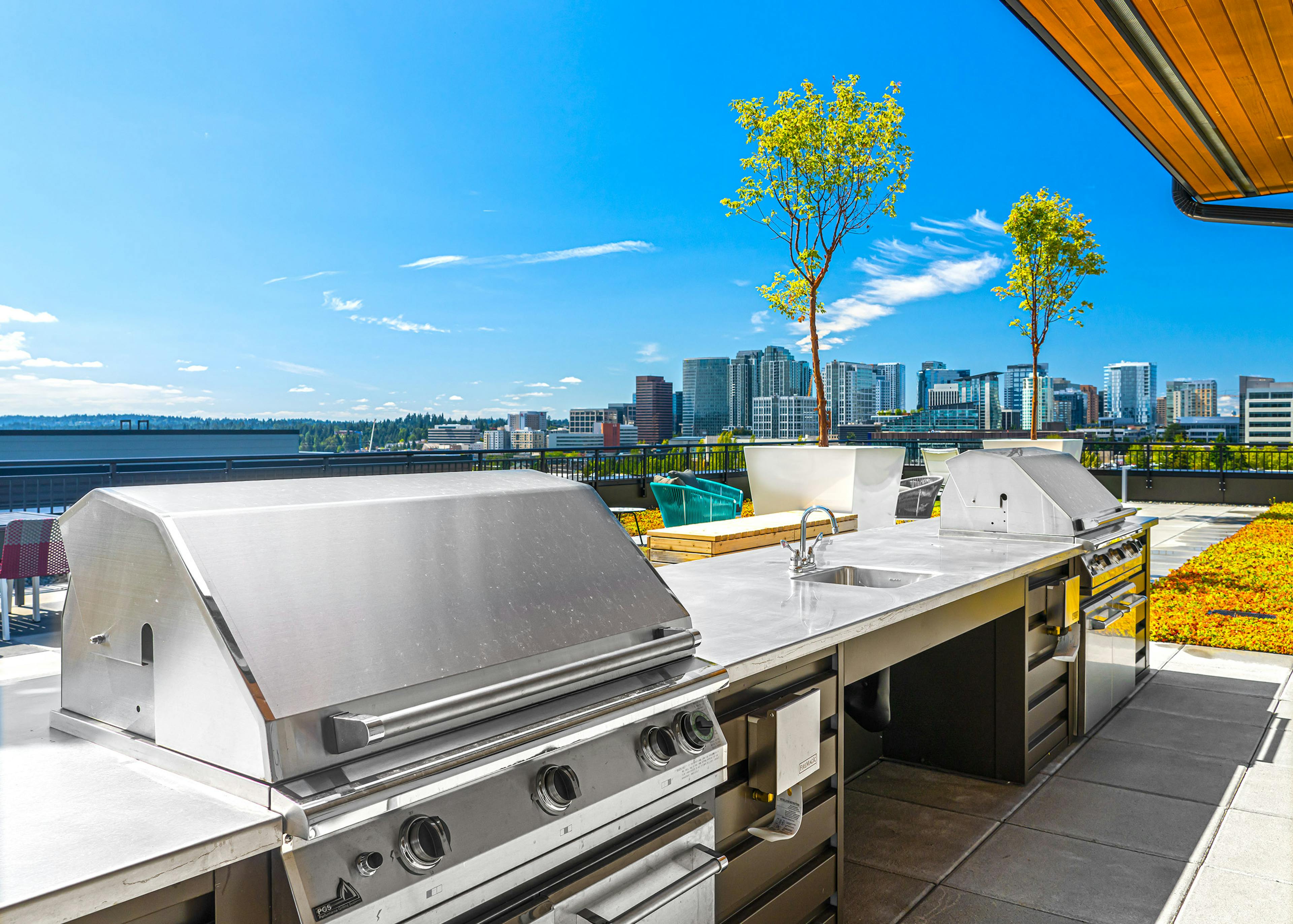 Two large outdoor stainless grills on the rooftop of AMLI Spring District apartments with scenic views of Downtown Bellevue