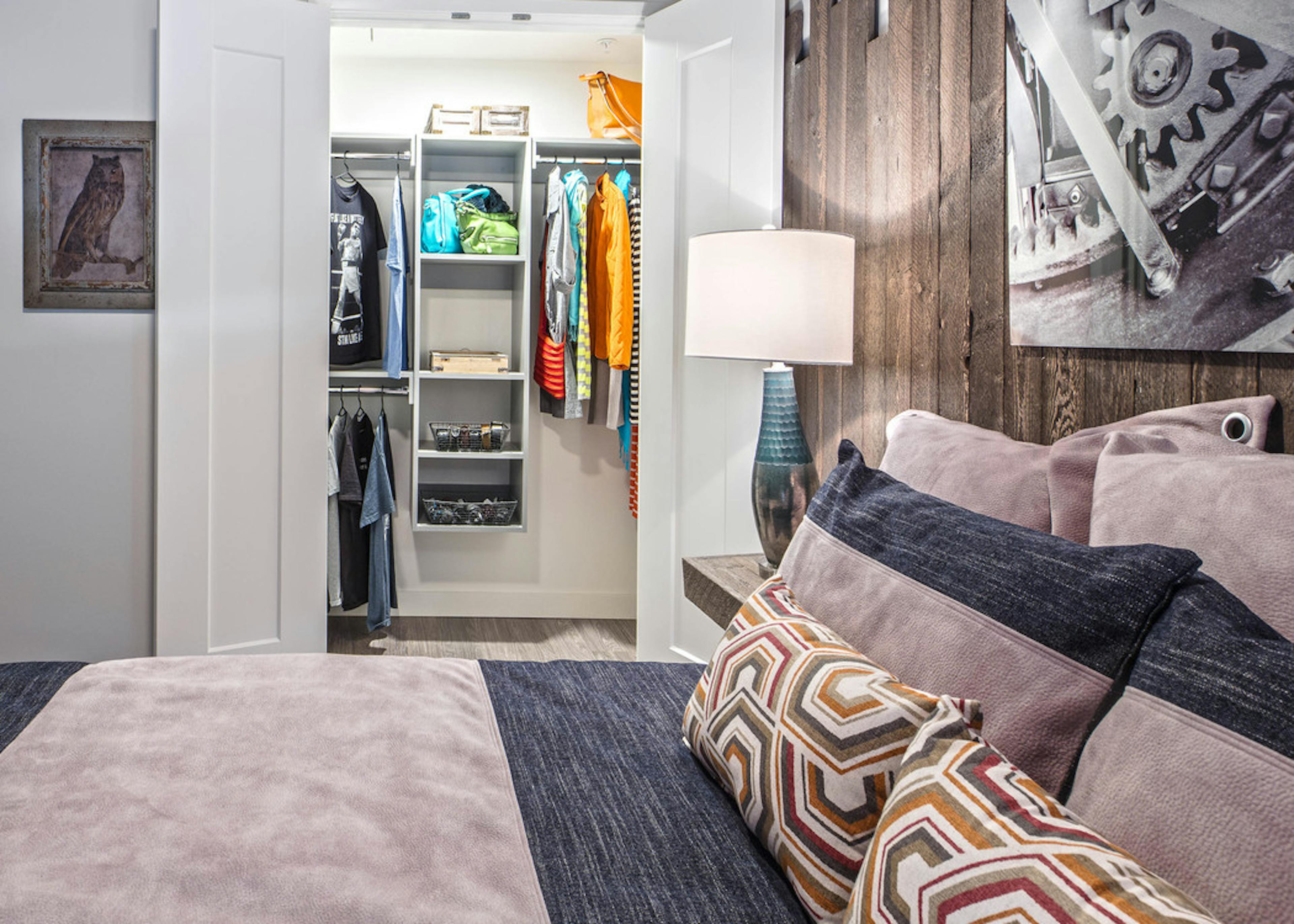 Interior view of apartment of AMLI Arc of bedroom with white walls room for a queen bed and walk-in California Closet