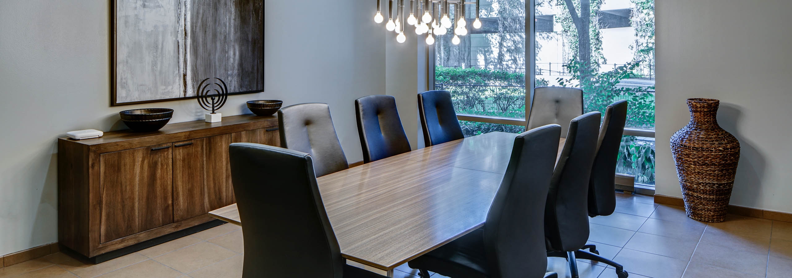 AMLI 900 conference room with a long modern table in the center surrounded by swivel chairs and floor to ceiling windows