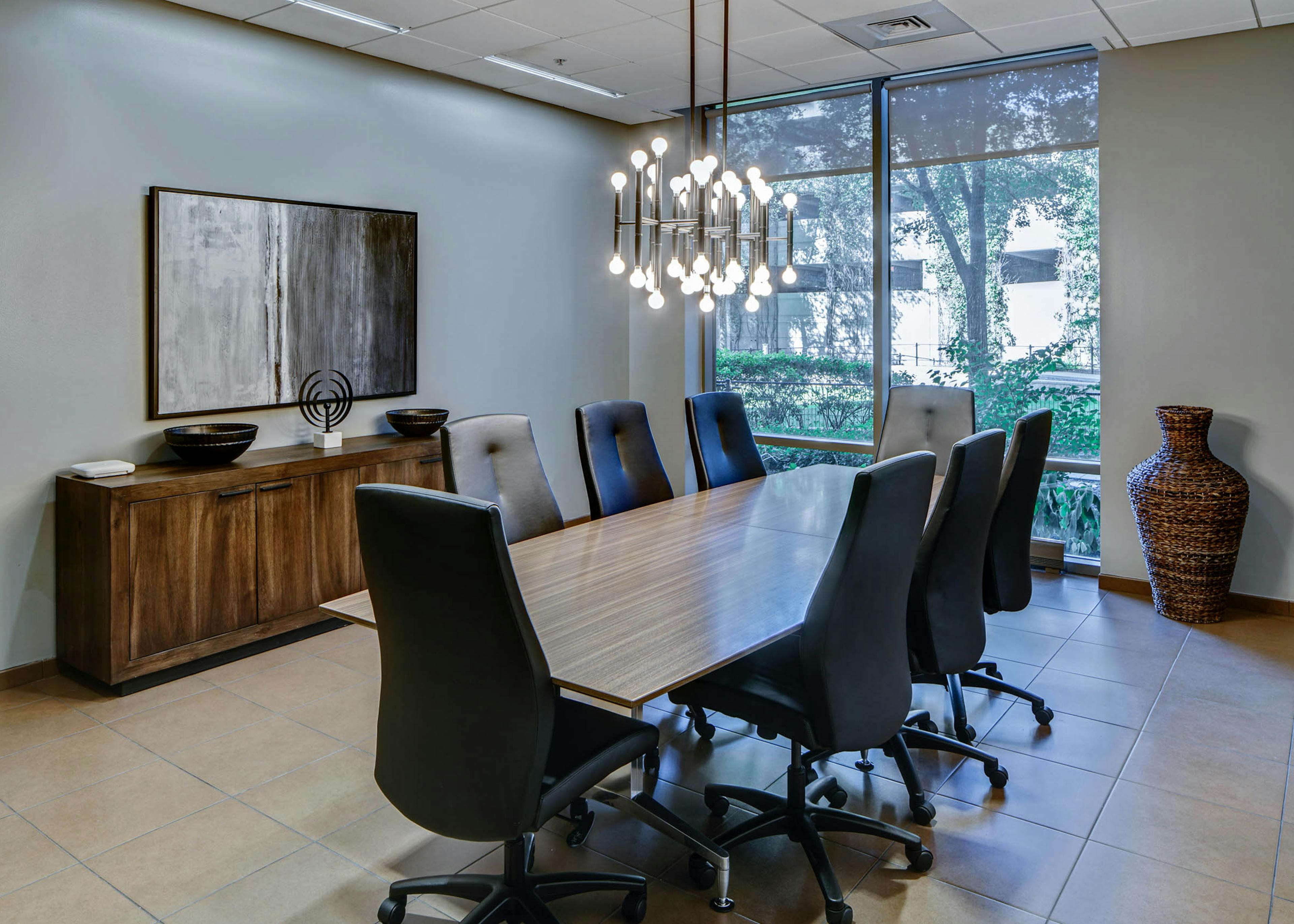 AMLI 900 conference room with a long modern table in the center surrounded by swivel chairs and floor to ceiling windows