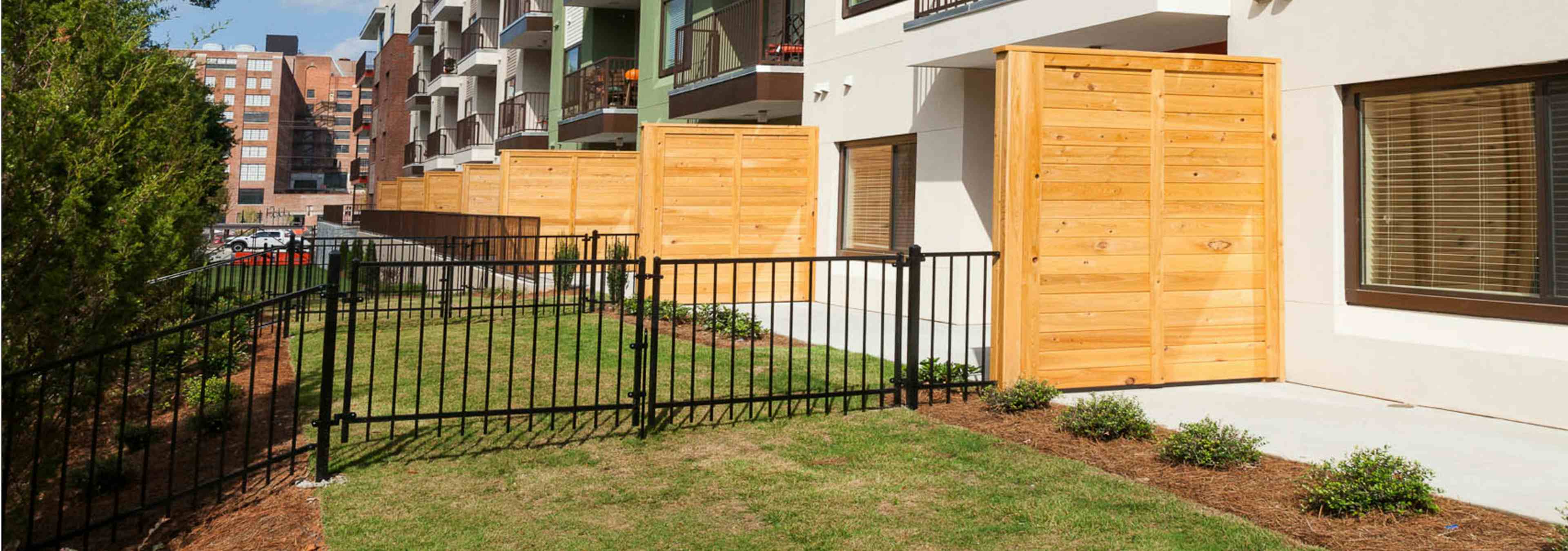 Exterior view of AMLI Ponce Park bottom floor apartments containing small private yards with iron fences separating them