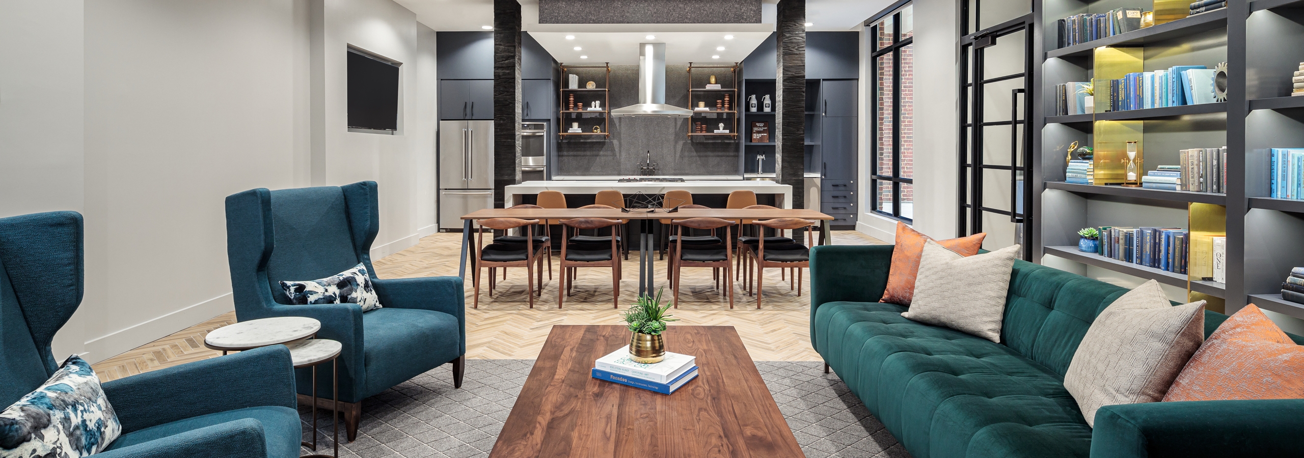 Tap room at AMLI Addison with a teal couch in front of a wall shelf with two chairs across and a wooden coffee table