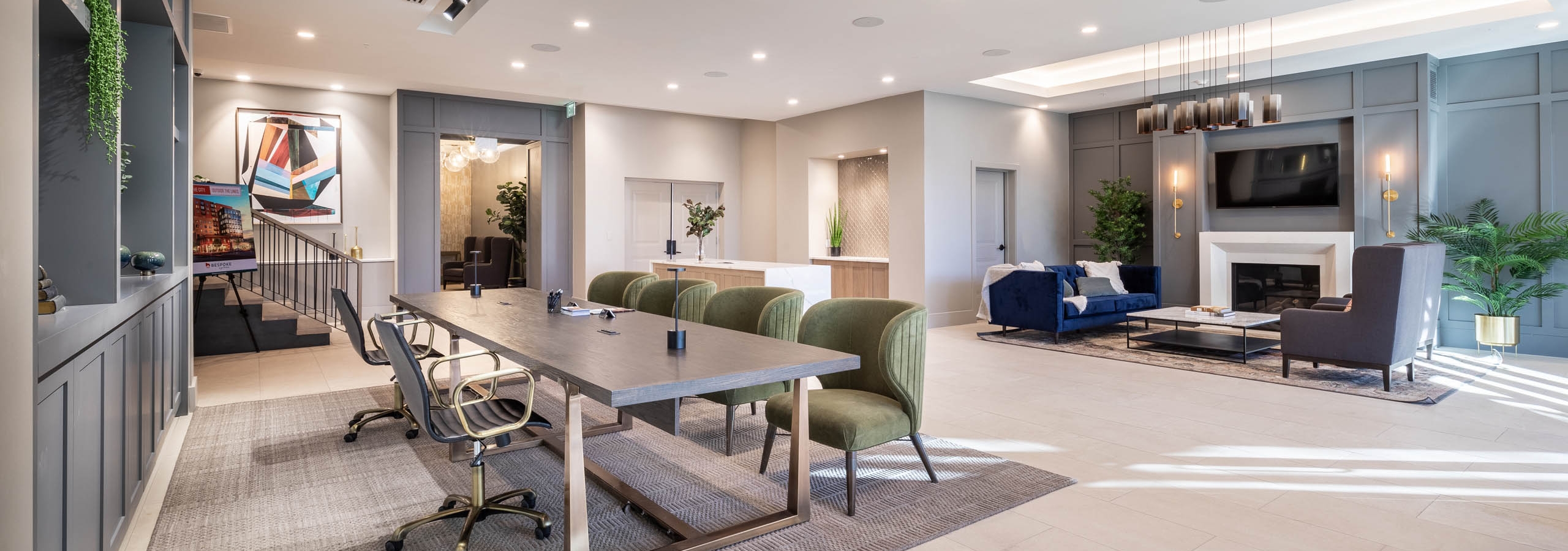 Close up of spacious conference table in AMLI at Uptown lobby with view of seating area and modern fireplace in background