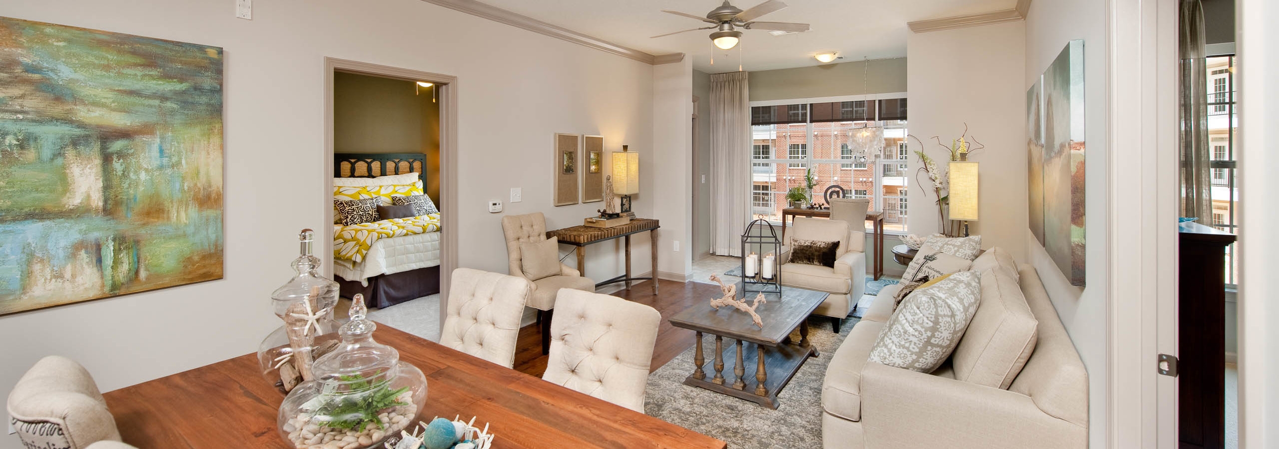 Elegantly styled dining room at AMLI North Point connecting to a living area with balcony doors in the background