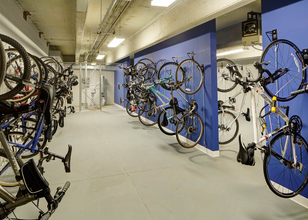 Interior view of bike storage room at AMLI Deerfield apartment community with blue walls and several vertical bike racks