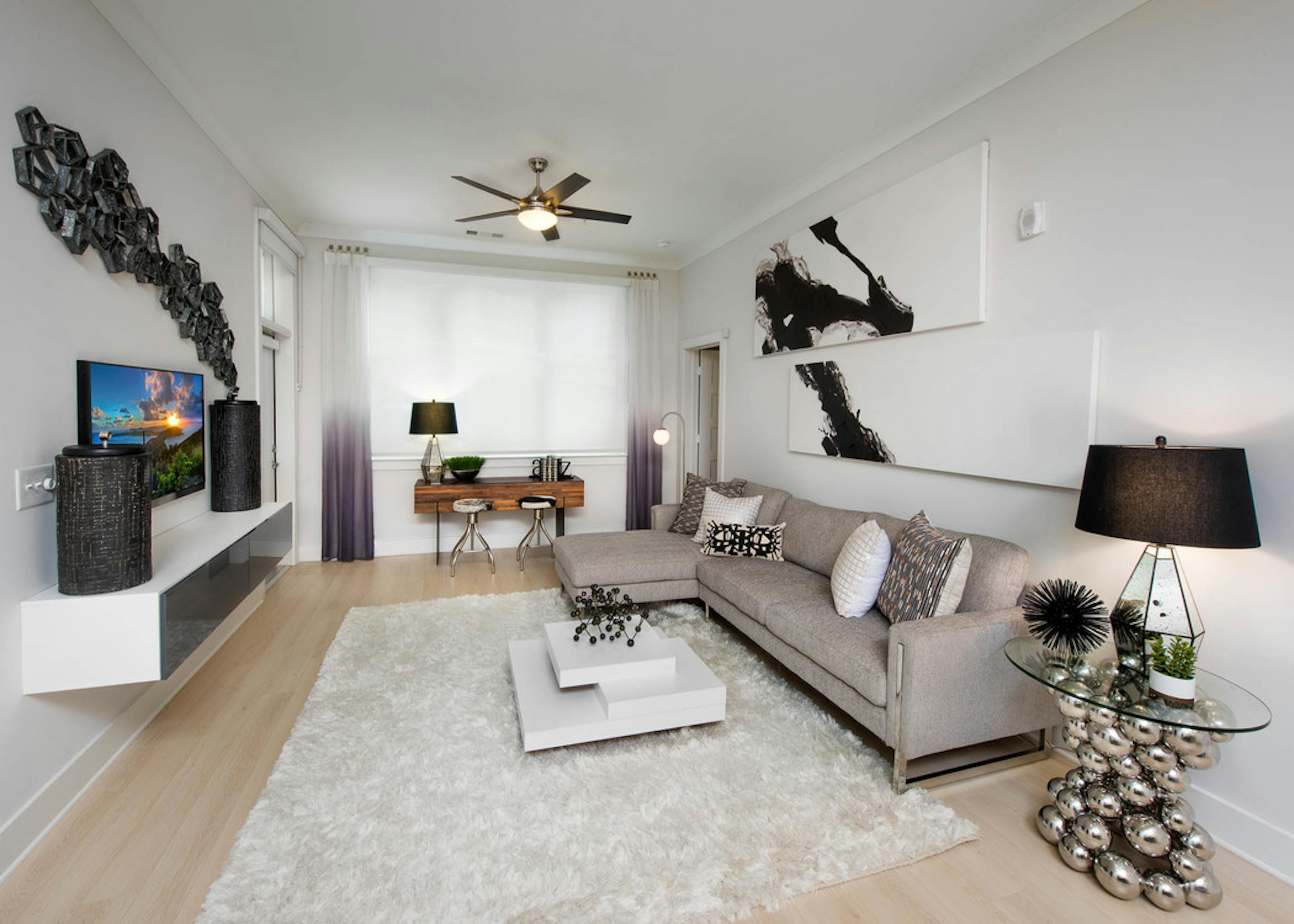 Alternate angle of AMLI Buckhead living room with black, white and beige color scheme with creme walls and light wood floors
