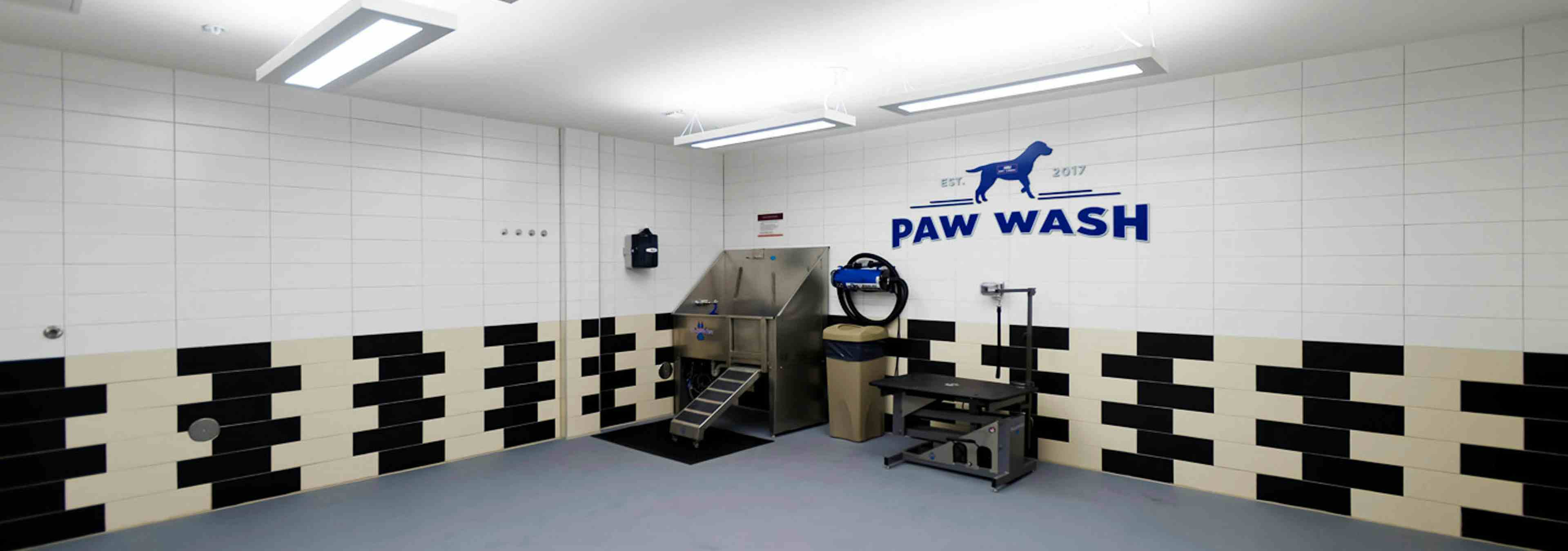 Interior view of the paw wash at AMLI Dry Creek apartments featuring a washing tub and grooming table and Paw Wash signage