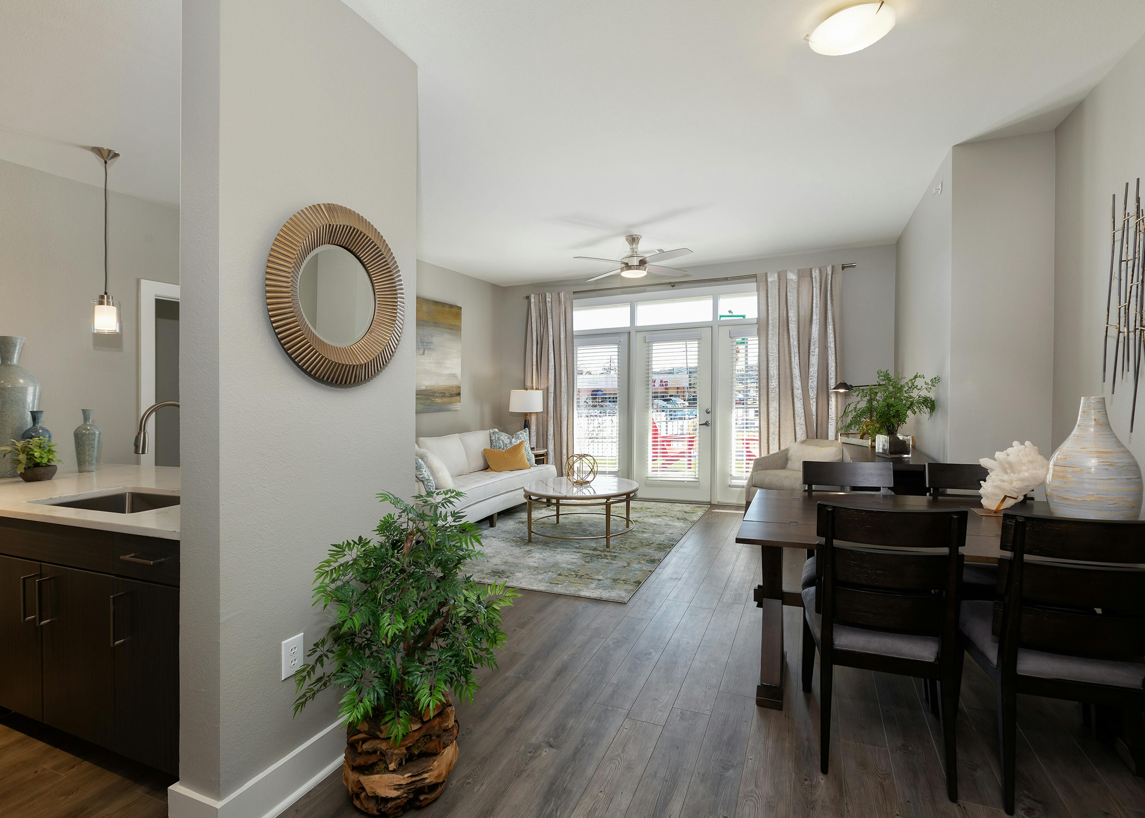 AMLI South Shore living room with dark hardwood and elegant decor with balcony doors revealing bright daytime view