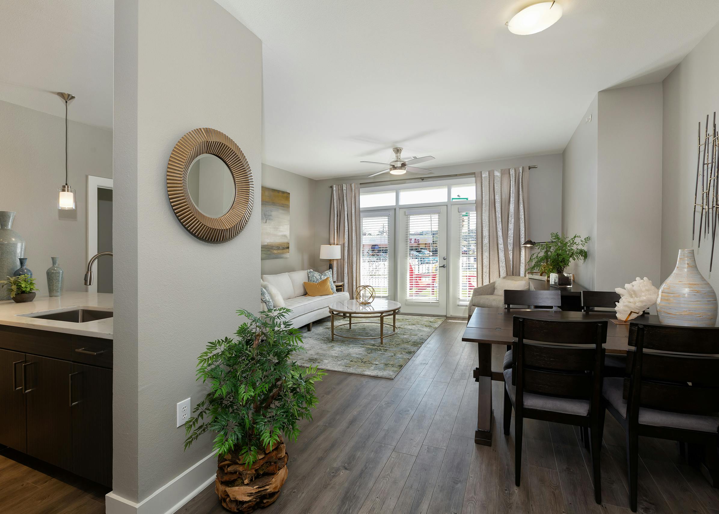 AMLI South Shore living room with dark hardwood and elegant decor with balcony doors revealing bright daytime view