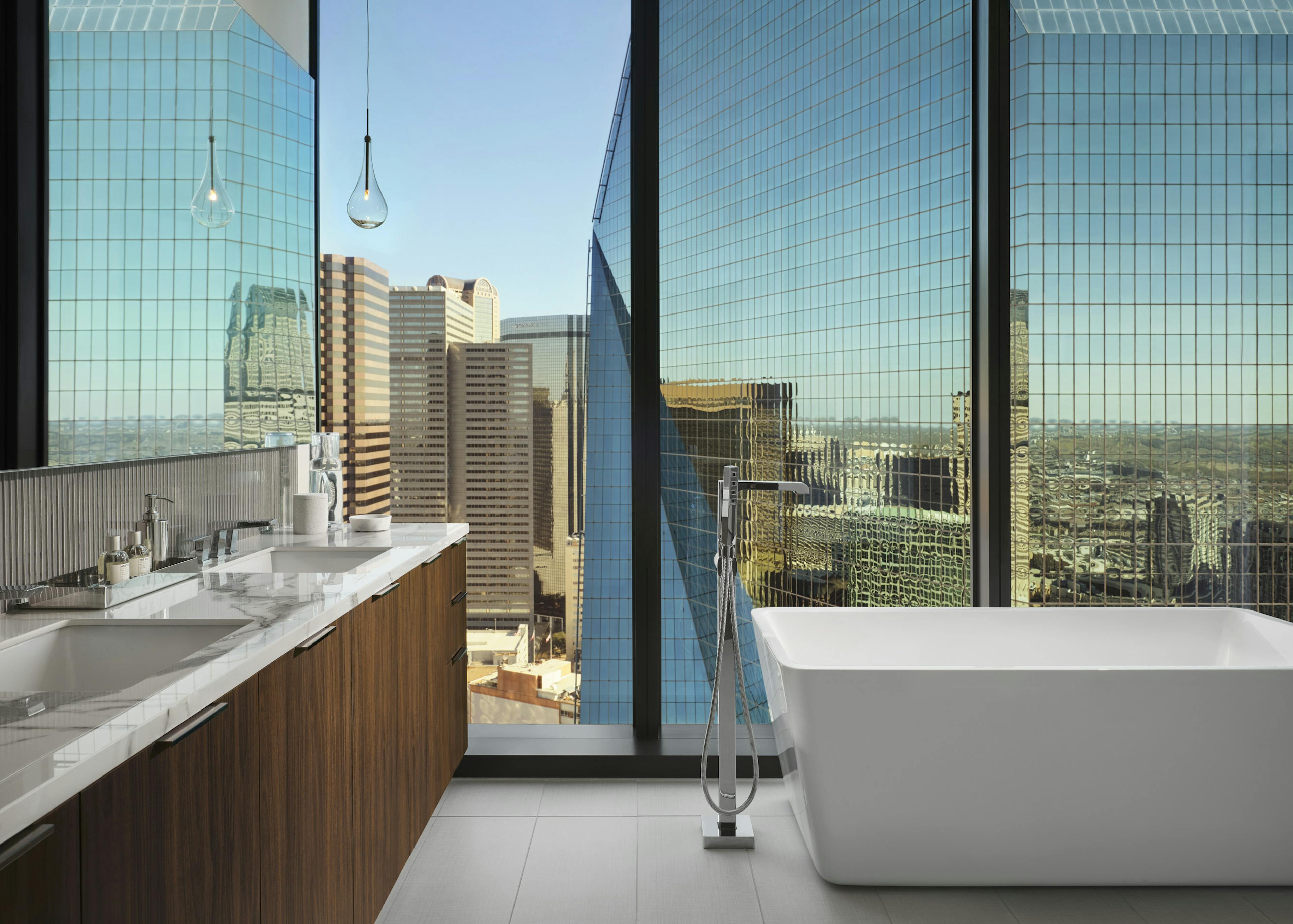 Interior view of AMLI Fountain Place apartment bathroom with free standing soaking tub in front of large window