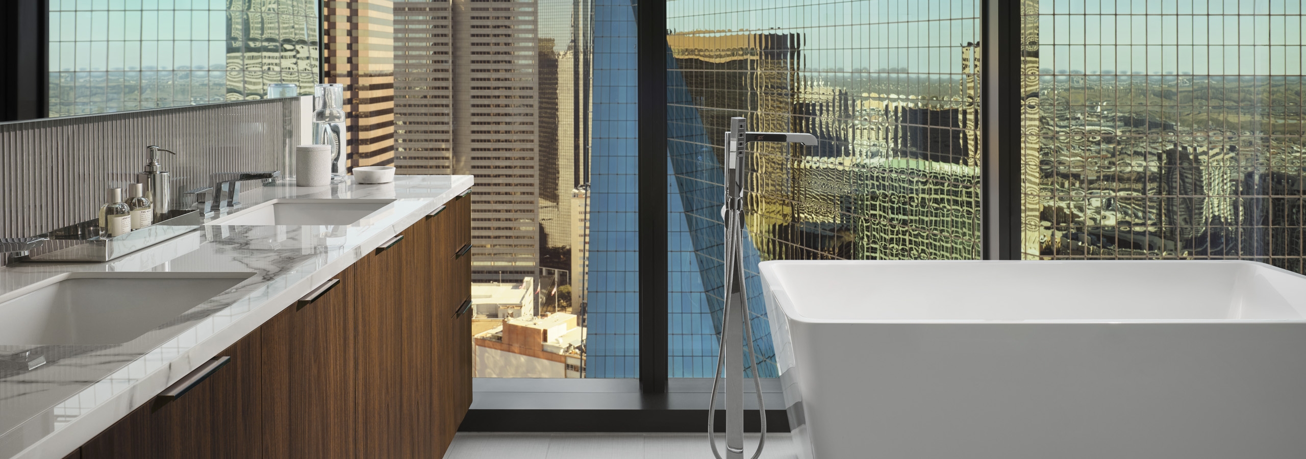Interior view of AMLI Fountain Place apartment bathroom with free standing soaking tub in front of large window
