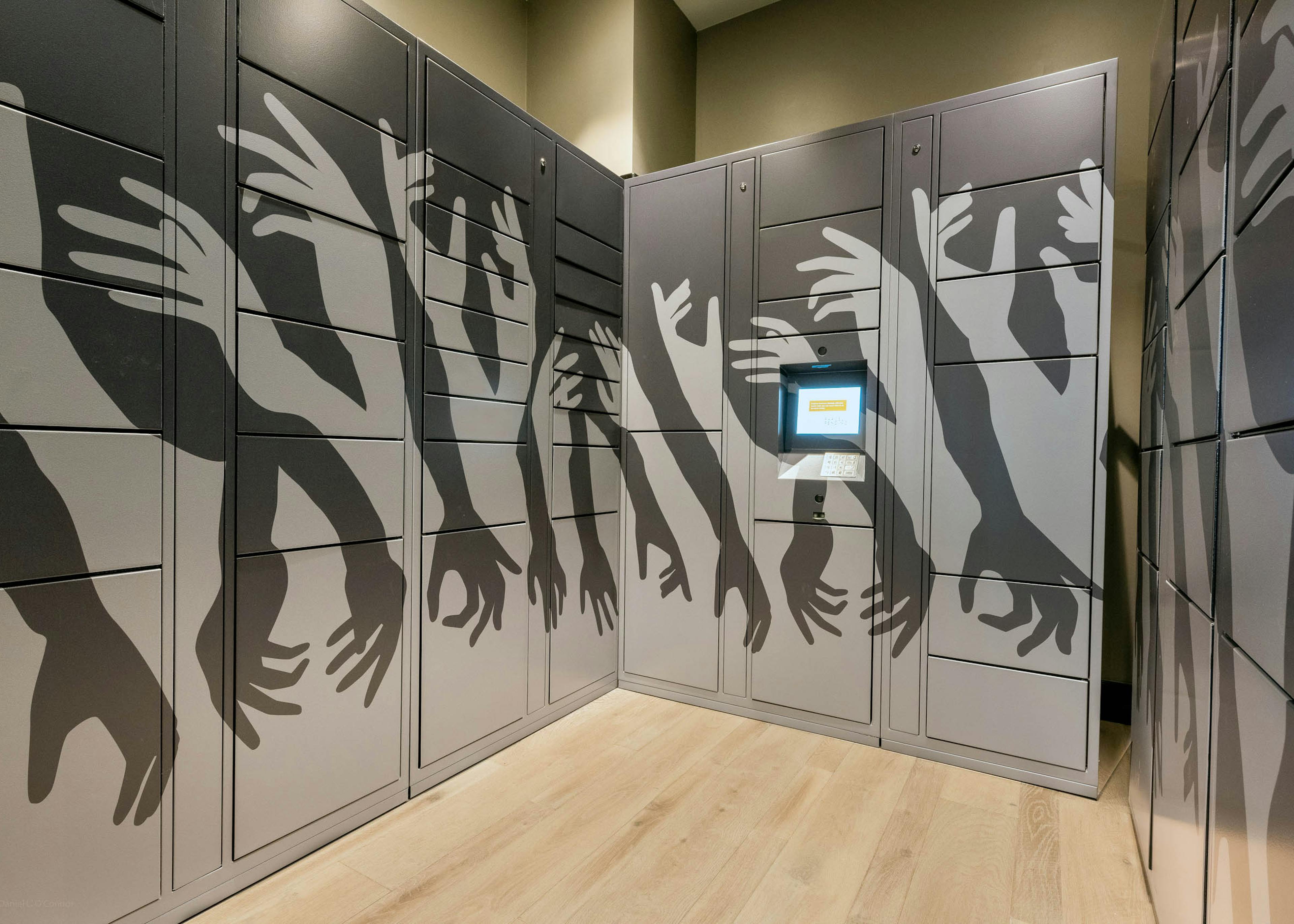 Package locker room at AMLI Art District apartments with artistic designs and a kiosk screen to enter access codes