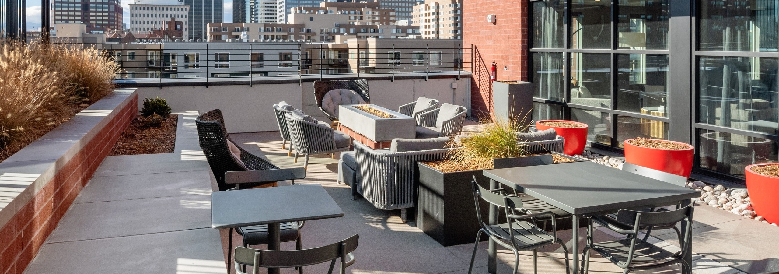 Rooftop lounge amenity space at AMLI at Uptown apartment community featuring ample seating options surrounded by city views